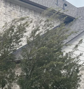 Completed roof-to-wall flashing repair by CM Roofing Pros in Sugar Land, TX, showing a flawless installation of new custom step flashing tucked neatly beneath the brick line and roof transition.